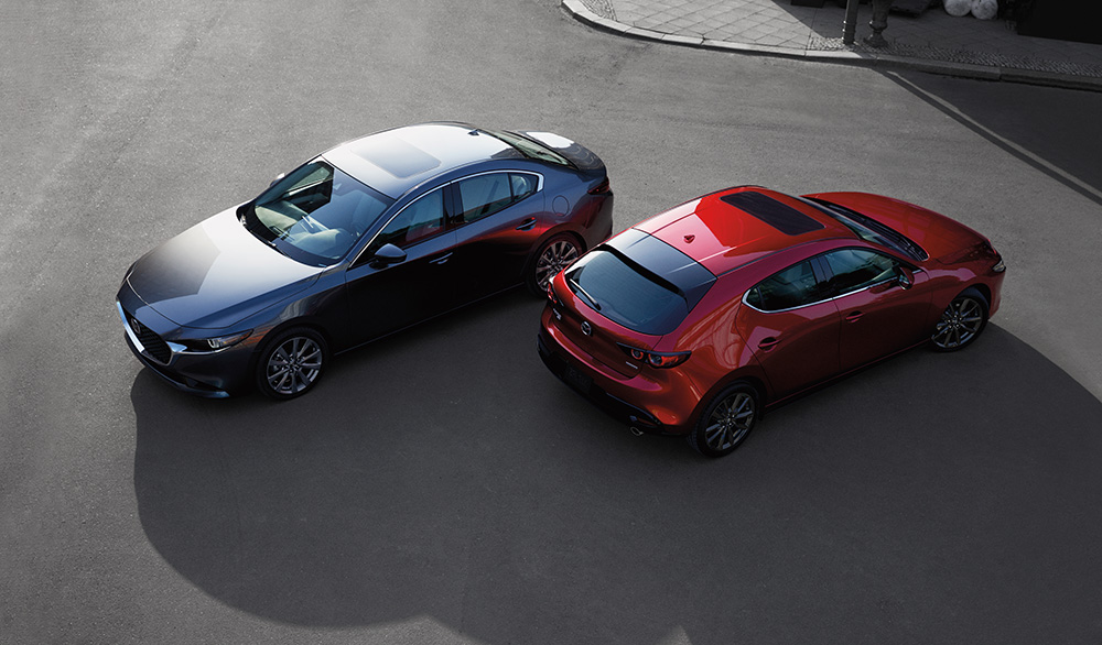 Mazda3 (acier) et Mazda3 Sport (rouge) 2020 presque dos à dos, vus de haut